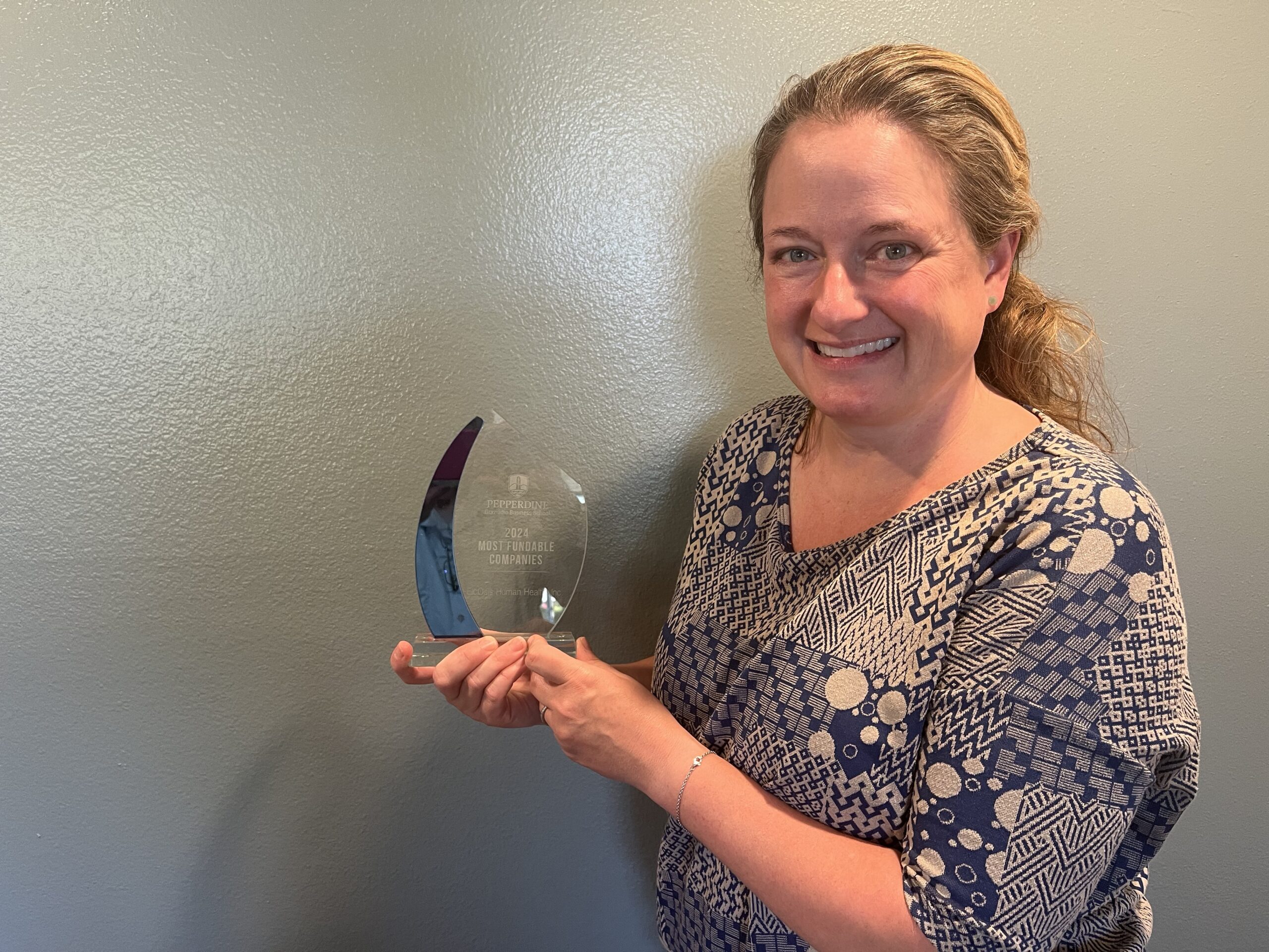 Cindy McReynolds, EicOsis CEO, holding the Pepperdine Business School Award for 2024 Most Fundable Company